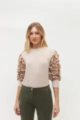 Remera negra de punto con mangas largas abullonadas con volantes.