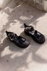 Sandalias de cuero color marrón con plataforma de goma negra.