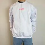 Buzo blanco de cuello redondo y corte oversize, con estampado en la espalda de la palabra "Amore" en rosa y negro.