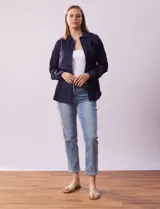 Camisa blanca de lyocell, marca Dash. Tiene cuello con solapa, abertura central con botones, mangas largas regulables con presilla y botón, y dos bolsillos delanteros aplicados.