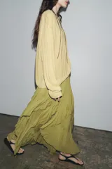 Falda midi color verde oliva, de tiro medio con cintura elástica y volantes asimétricos.