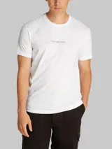 Remera blanca de manga corta con cuello redondo y logo de Calvin Klein Jeans estampado en el pecho.
