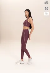 Top deportivo color borgoña con detalles de piping blanco en los bordes. El tejido Sense Pro® tiene tacto suave, transpirabilidad extrema y un soporte medio que realza las formas sin perder libertad.