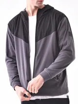 Campera deportiva azul con paneles negros en la parte superior y capucha. Cierre frontal con cremallera.