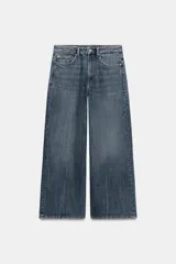 Pantalón de jean azul de tiro bajo, corte ancho y bolsillos delanteros y traseros. Cierre frontal con cremallera y botón metálico.