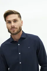 Camisa de lino color beige, de manga larga, corte semi slim y logo bordado en el pecho.