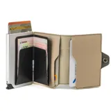 Billetera compacta de la colección Alabama de Baleine Co., confeccionada en símil cuero color verde y beige con estructura interna de aluminio. Cuenta con capacidad para 5 tarjetas con sistema de eyección mediante clip, compartimento para billetes, espacio para documentos y protección RFID.