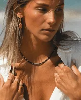 Collar corto de cuentas facetadas negras y detalles de acero plateado.