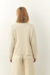 Cárdigan marrón de tejido de punto industrial con escote en V, combinación de puntos y botones en las mangas.