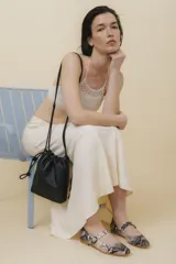 Zapato tipo Mary Jane de charol color borgoña, con punta redondeada, tira sobre el empeine con hebilla y suela de cuero.