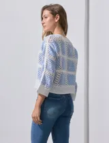 Buzo calado de acrílico, marca Sioni, color celeste y blanco, con cuello a la base y mangas tres cuartos.
