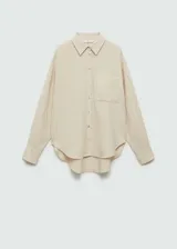 Camisa color crema de bambula, con cuello camisero, manga larga con puños abotonados, bolsillo de parche en la parte delantera, diseño oversize y cierre delantero con botones.