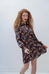 Vestido corto con estampado floral multicolor, cuello camisero y mangas largas abullonadas.