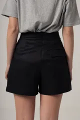 Short negro de tiro alto con pliegues y textura, de corte holgado.