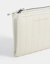 Billetera pequeña color rosa con textura acolchada y pespuntes verticales. Tiene cierre superior y broche con botón para cerrar.
