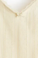 Top color crema de punto pointelle de algodón con breteles finos ajustables y escote en V con detalle de puntilla.