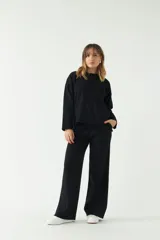 Sweater negro de punto suave con cuello redondo y hombros caídos.