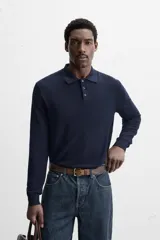Polo de hombre color gris oscuro, de punto ligero tejido en hilatura con mezcla de seda y algodón. Tiene cuello solapa con cierre frontal de botonadura, manga larga y acabados en rib.