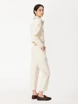 Pantalón color crema de corte slouchy con pinzas en las rodillas y bordados de hongos y chiles con strass.