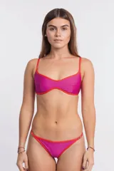 Top de bikini color fucsia con ribete en color rojo anaranjado. El corpiño es de estilo bralette con escote curvo y tirantes finos ajustables.