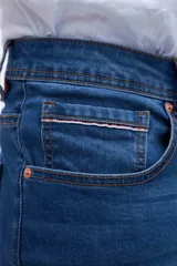 Jean azul de corte slim fit, con cintura media y cierre con botón y cremallera.