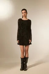Vestido mini negro de poliéster, entallado, con cuello bote y mangas largas transparentes con estampado floral en relieve.