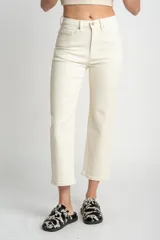Pantalón de jean color crudo, corte recto, tiro medio, confeccionado en algodón peinado con elastano.