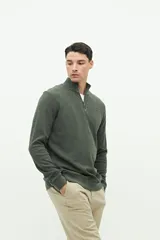 Buzo verde oscuro de felpa con medio cierre, cuello alto y logo de goma en el pecho.