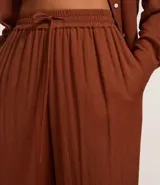 Pantalón de cambraia color marrón, de cintura alta con elástico y lazo.