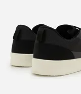 Championes Viko de hombre, color negro con suela blanca, confeccionados en poliéster con recortes y suela de EVA. Diseño casual y confortable.