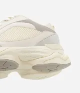 Championes dad sneaker grises con recortes en cuero sintético, cordones blancos y suela chunky de goma color crema.