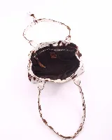 Cartera baguette de cuero con estampado animal print de vaca en tonos marrón y blanco. Tiene forro interior, un bolsillo amplio y broches laterales para ajustar el tamaño.