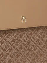 Mochila Tommy Hilfiger color marrón con monograma TH en jacquard, asa superior, cierre de solapa, compartimento principal, dos correas ajustables y logo metalizado TH en la parte delantera.