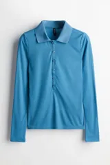 Remera polo celeste entallada de punto transparente, con cuello clásico, tapeta de botones y mangas largas.