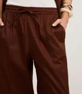 Pantalón wide leg marrón de sarga, con cintura alta, elástico, lazo y frisos delanteros.