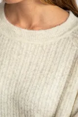 Sweater color beige de tejido texturado, con cuello redondo y mangas largas.