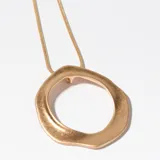 Collar dorado con dije circular irregular.