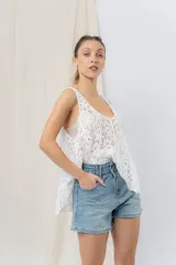 Musculosa blanca de encaje calado con diseño floral, escote en V y breteles anchos.