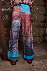 Pantalón de pana sublimado con estampado de montañas y cielo celeste. Tiro medio, corte evasé similar a un oxford, con doble botón y cierre.