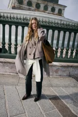 Bolso tipo shopper de gran tamaño, confeccionado en pana marrón con textura acanalada. Presenta un asa de hombro de cuero marrón y un detalle de tira ajustable con hebilla metálica en la parte frontal.