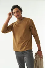Remera de manga larga color marrón con cuello redondo y logo bordado en el pecho.