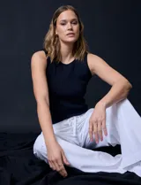 Musculosa negra en tejido acanalado, con cuello redondo a la base y sin mangas.
