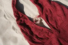 Traje de baño enterizo marrón acanalado, con escote profundo en V y abertura en el centro unida por una argolla dorada.