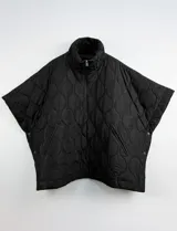 Poncho acolchado color mostaza con cuello alto y abertura frontal con cierre. Presenta un patrón capitoné de formas ovaladas y bolsillos delanteros.