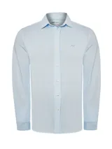 Camisa celeste con finas rayas verticales blancas, de manga larga y cuello camisero.
