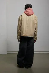 Campera color beige de sarga de algodón con efecto lavado, corte holgado, cuello clásico, cierre frontal con cremallera, bolsillos delanteros de parche, bolsillo interior con botón a presión, botones a presión ajustables en los puños y en los laterales del bajo y forro interior.