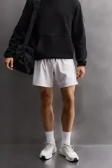 Shorts deportivos color verde oliva confeccionados en tejido técnico ligero y elástico. Cuenta con forro interior, cintura elástica ajustable con cordón, bolsillos laterales, bolsillo de seguridad en espalda con cierre de cremallera, bajo con aberturas laterales y logo estampado en la pierna.