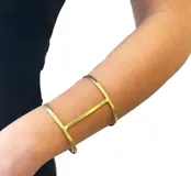 Pulsera brazalete de bronce dorado, ajustable para usar en la muñeca o en el antebrazo.