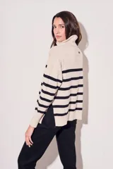 Polera de algodón de rayas negras y beige, con cuello alto y corte ajustado.