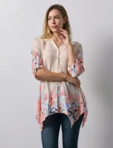 Blusa de gasa color beige con estampado floral en tonos rosa y celeste. Tiene cuello a la base, escote en V y abertura central con botones. Las mangas son 3/4 y regulables con presilla y botón.